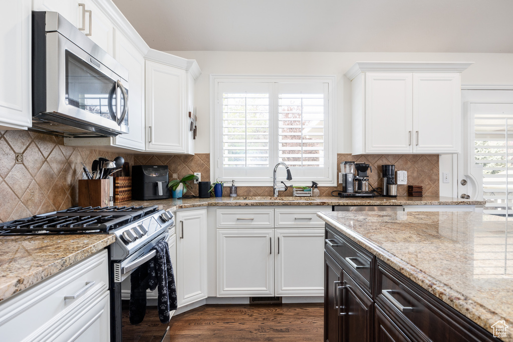 Kitchen with backsplash, stainless steel appliances, and a wealth of natural light