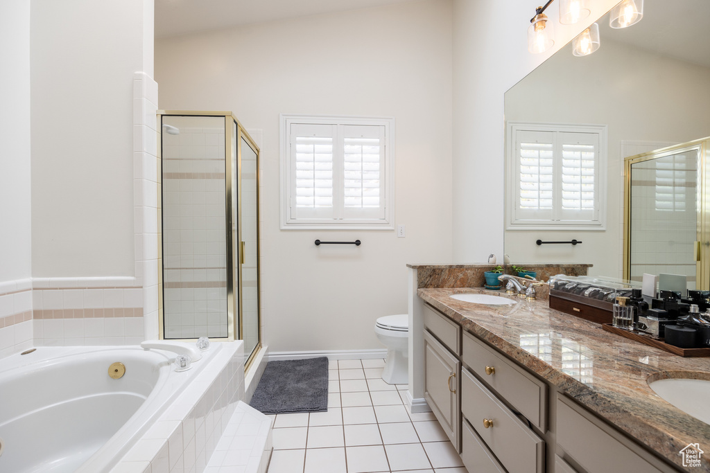 Full bathroom with a healthy amount of sunlight, double vanity, tile floors, and lofted ceiling