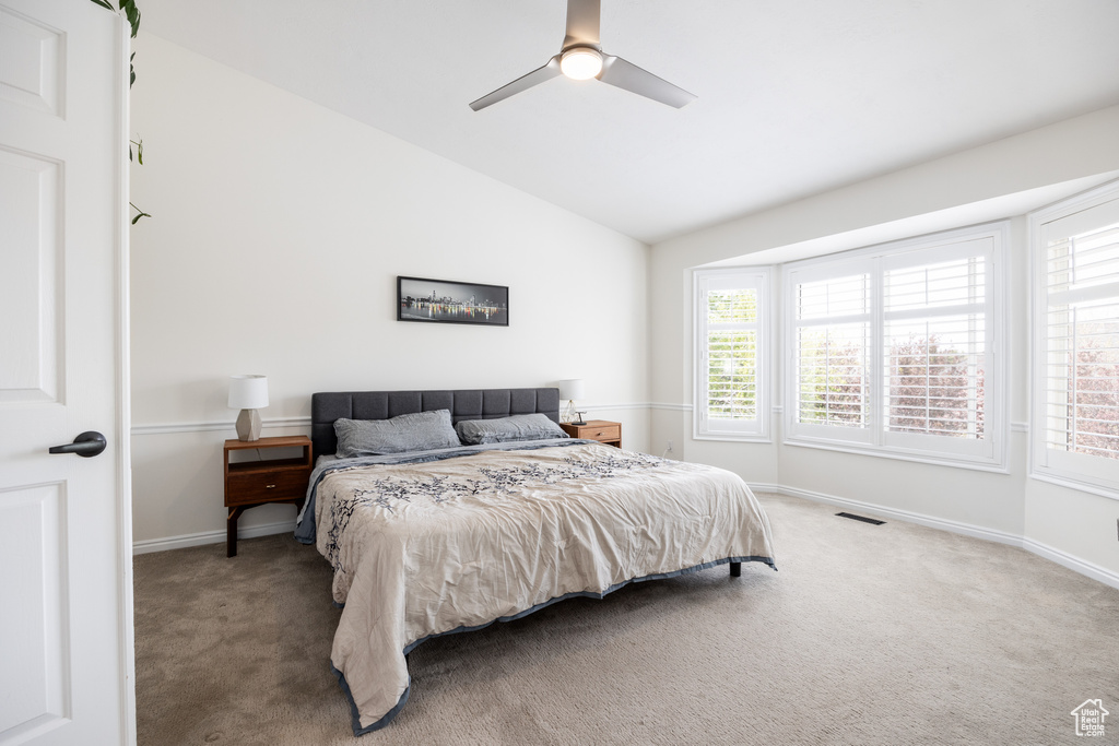 Bedroom featuring carpet floors, ceiling fan, and vaulted ceiling
