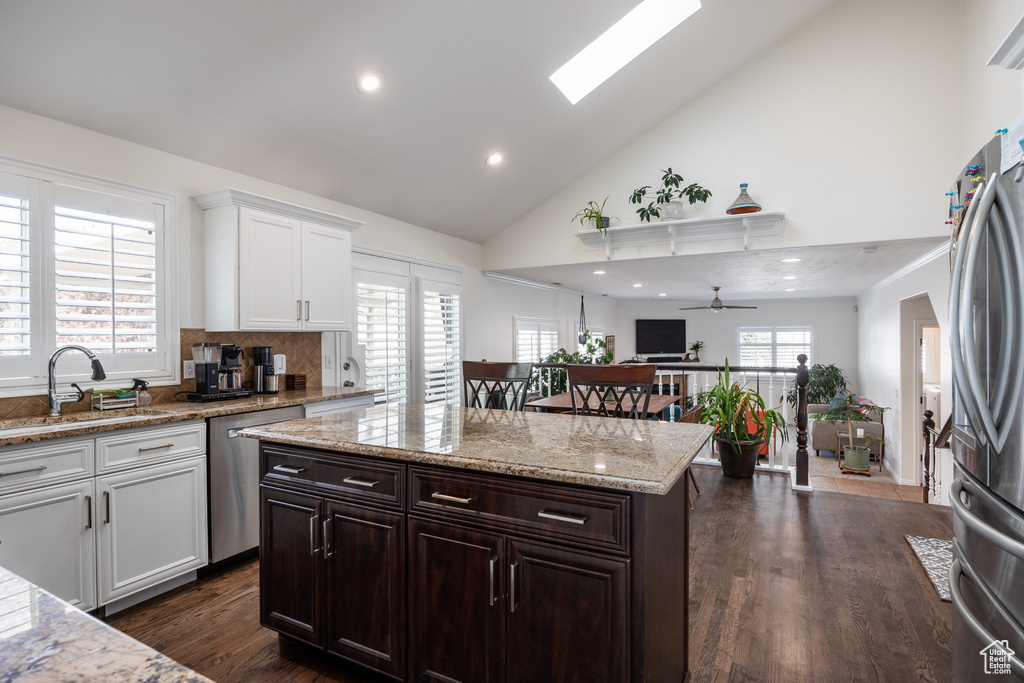 Kitchen featuring white cabinetry, appliances with stainless steel finishes, sink, a skylight, and ceiling fan