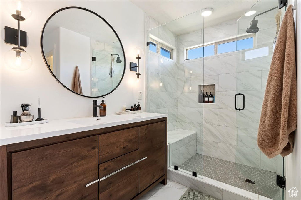 Bathroom with an enclosed shower, tile floors, and dual bowl vanity