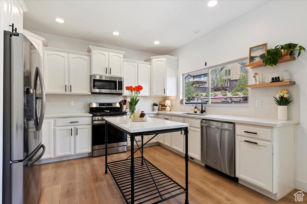 Kitchen featuring sink, light hardwood / wood-style floors, white cabinetry, and stainless steel appliances