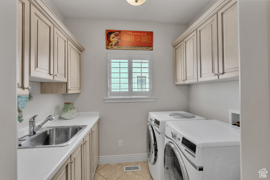 Laundry area featuring light tile flooring, washer and clothes dryer, hookup for a washing machine, sink, and cabinets