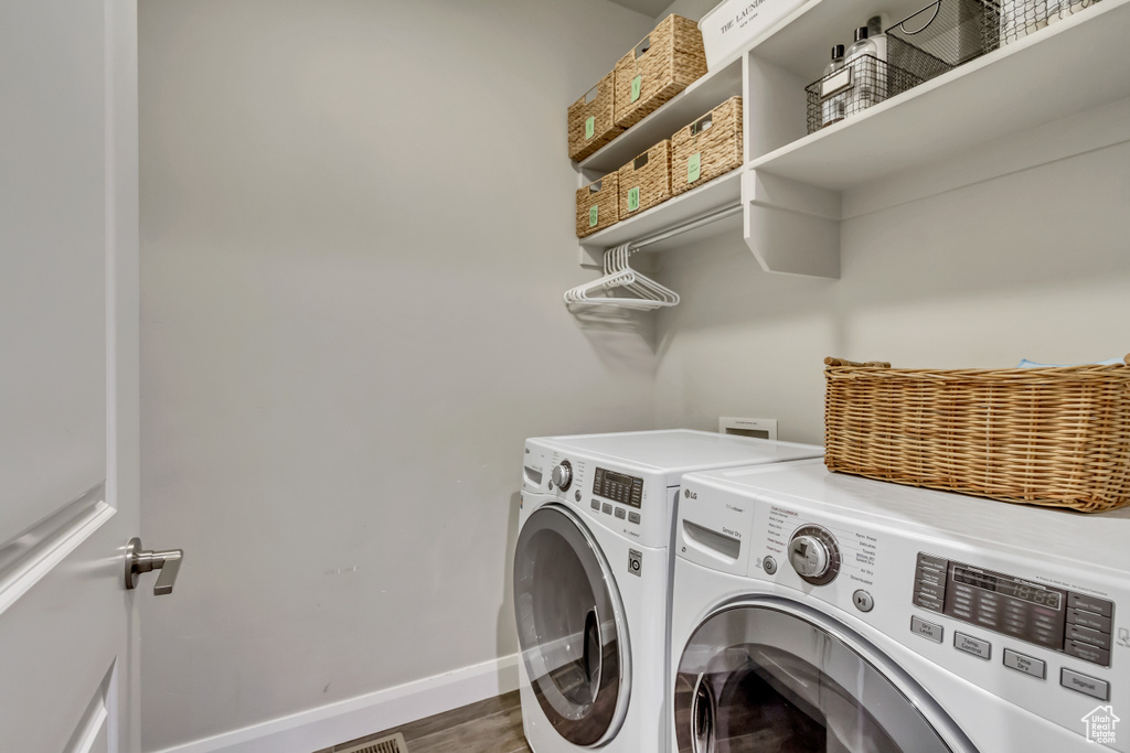 Laundry room featuring wood-type flooring and washer and clothes dryer