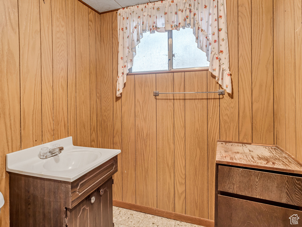 Bathroom with wood walls, vanity, and toilet