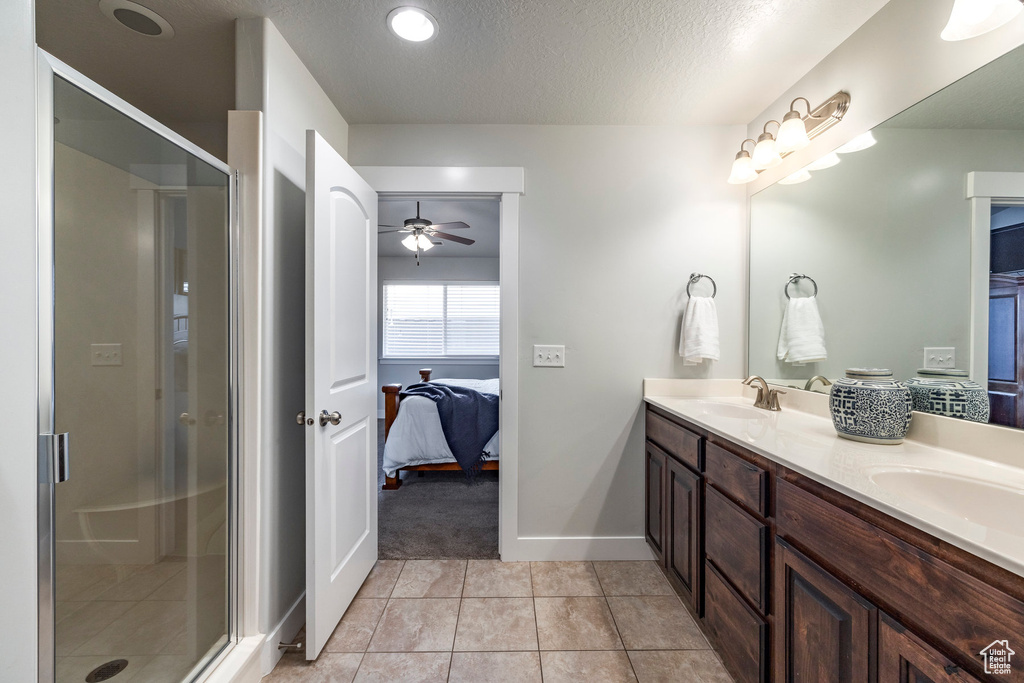 Bathroom featuring walk in shower, ceiling fan, dual bowl vanity, and tile floors