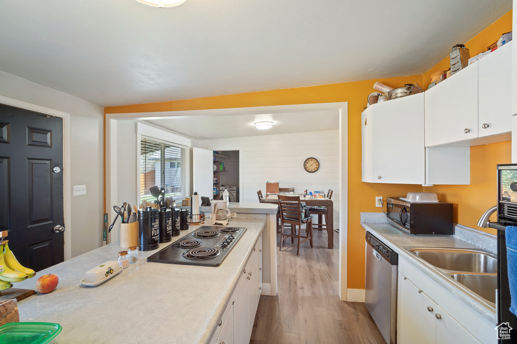 Kitchen featuring light hardwood / wood-style floors, stainless steel appliances, white cabinets, and sink