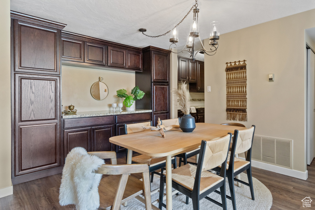 Dining space featuring dark hardwood / wood-style flooring and a notable chandelier