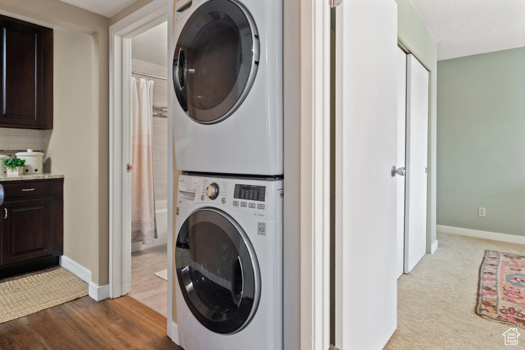 Washroom featuring carpet floors and stacked washer and clothes dryer
