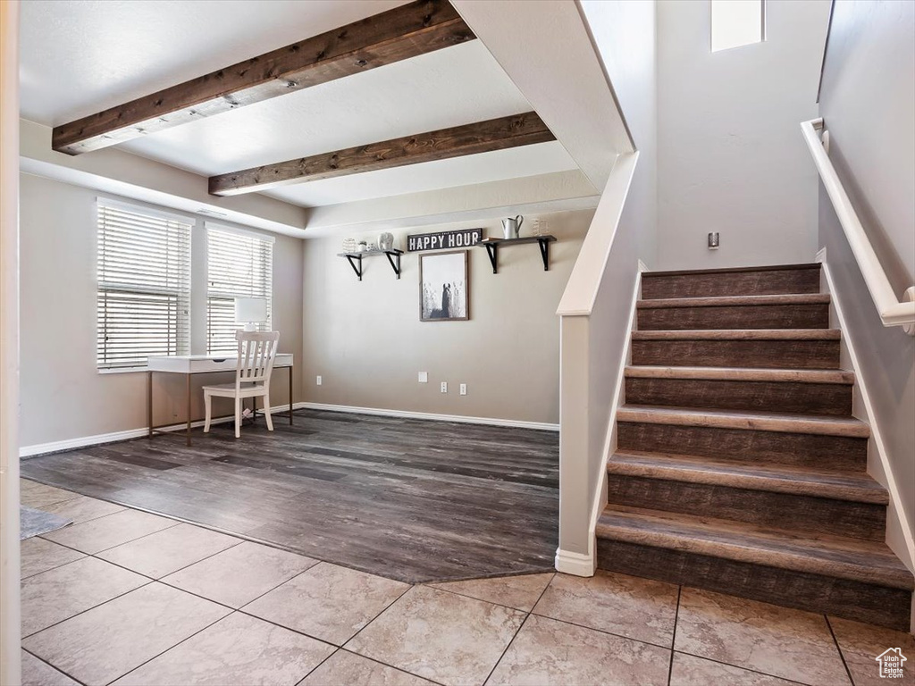 Stairs featuring hardwood / wood-style floors and beam ceiling