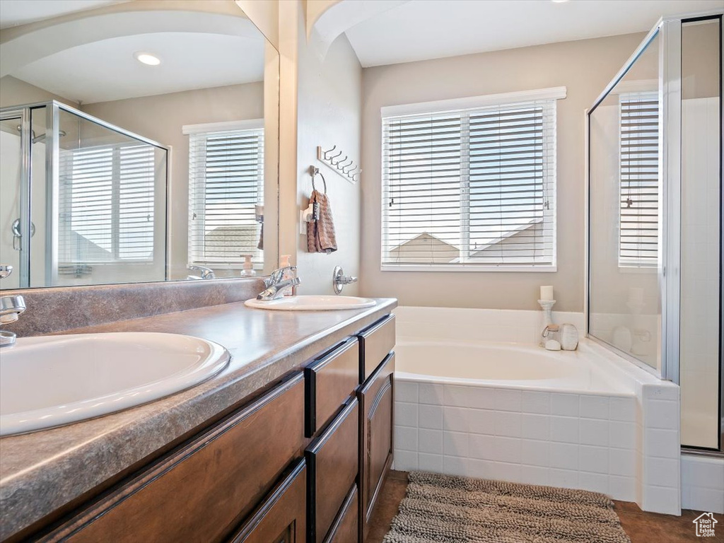 Bathroom featuring plenty of natural light, separate shower and tub, dual bowl vanity, and tile flooring