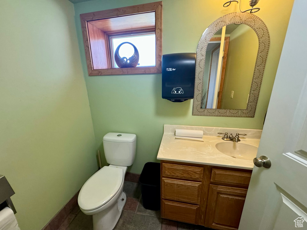 Bathroom featuring tile floors, vanity, and toilet