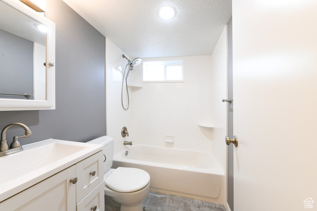 Full bathroom with shower / bath combination, vanity, toilet, and a textured ceiling