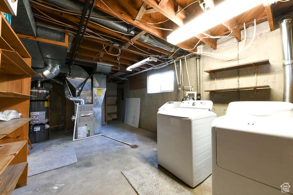 Basement with water heater, heating utilities, and separate washer and dryer