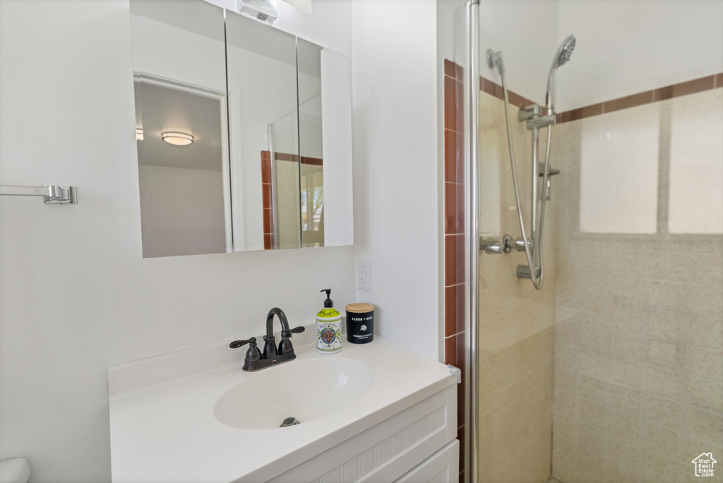 Bathroom with a shower with shower door and vanity