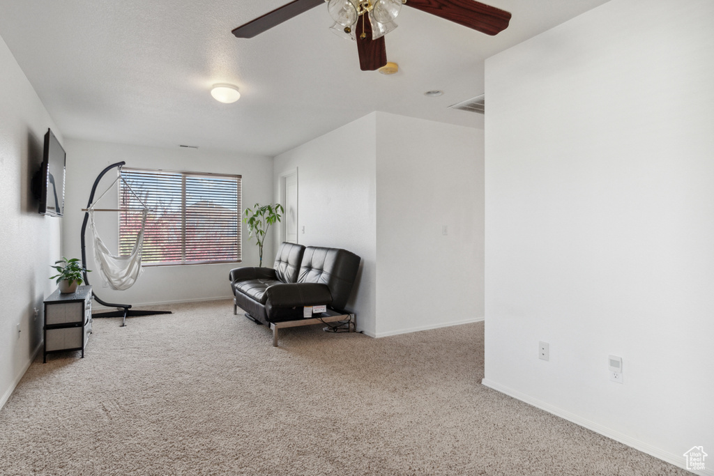Living area with ceiling fan and carpet floors