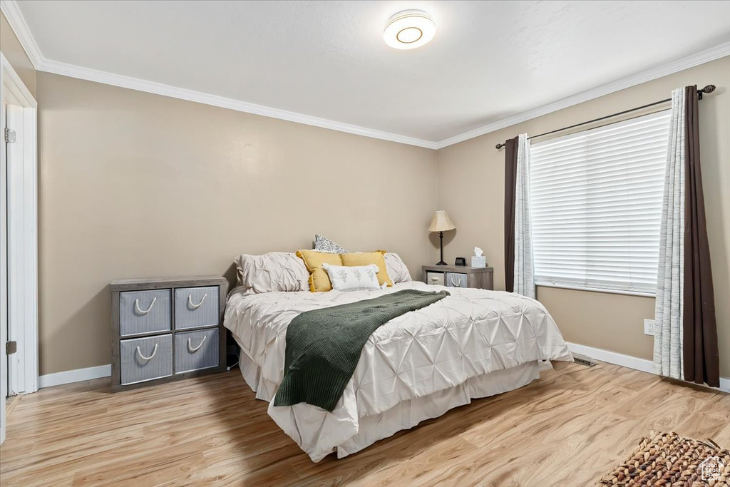 Bedroom featuring hardwood / wood-style flooring and ornamental molding
