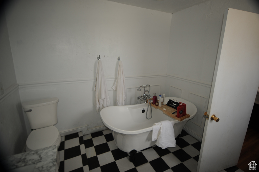 Bathroom featuring toilet, tile flooring, and a tub