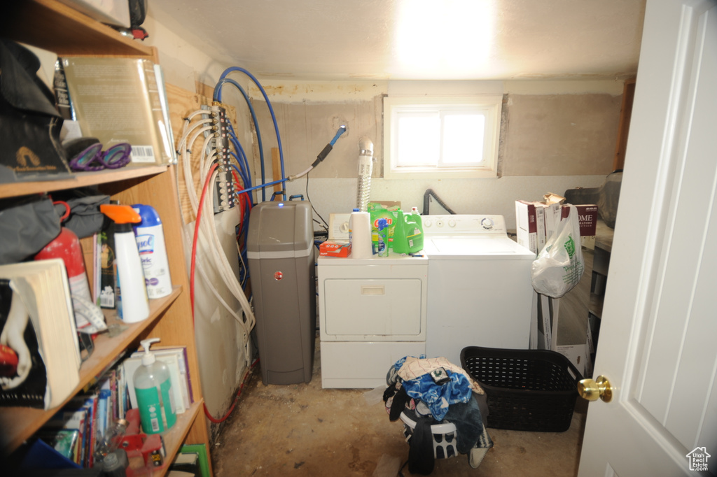 Washroom featuring water heater and washer and clothes dryer
