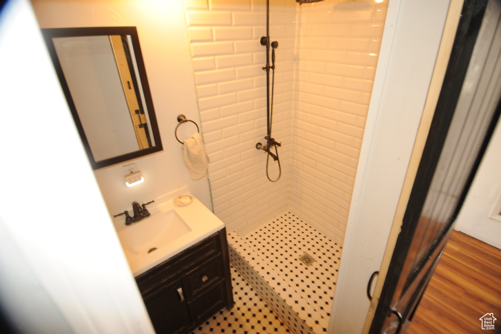 Bathroom featuring vanity, hardwood / wood-style floors, and a tile shower