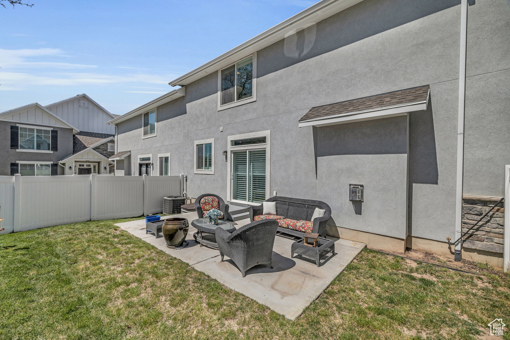 Back of property featuring a patio, a yard, an outdoor living space with a fire pit, and central AC unit