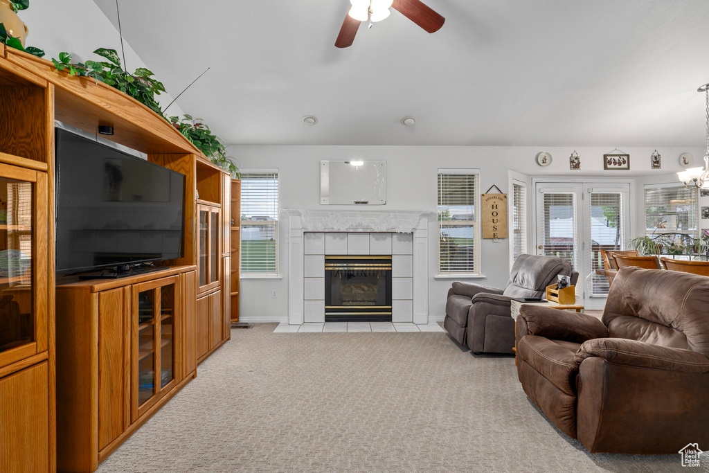 Living room featuring light colored carpet, a tile fireplace, and ceiling fan