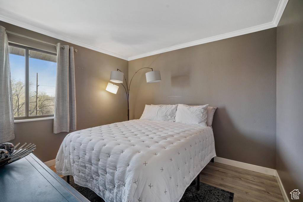 Bedroom featuring hardwood / wood-style floors and ornamental molding