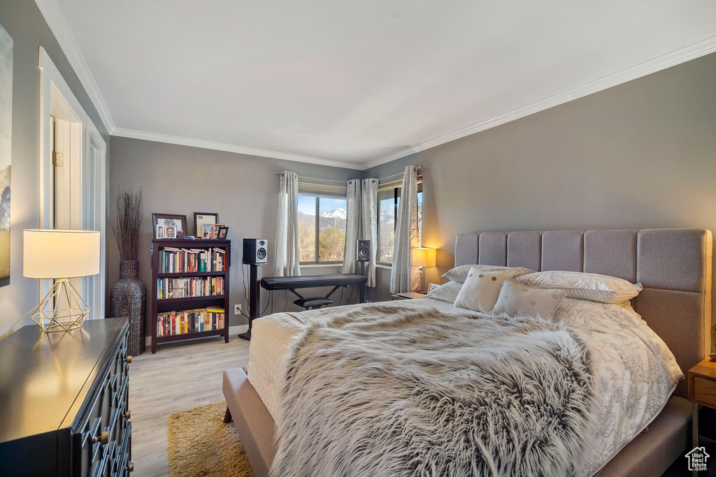 Bedroom featuring light hardwood / wood-style floors and crown molding