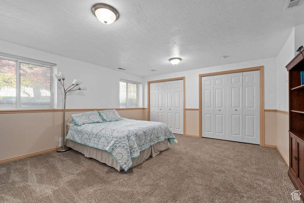 Carpeted bedroom featuring two closets
