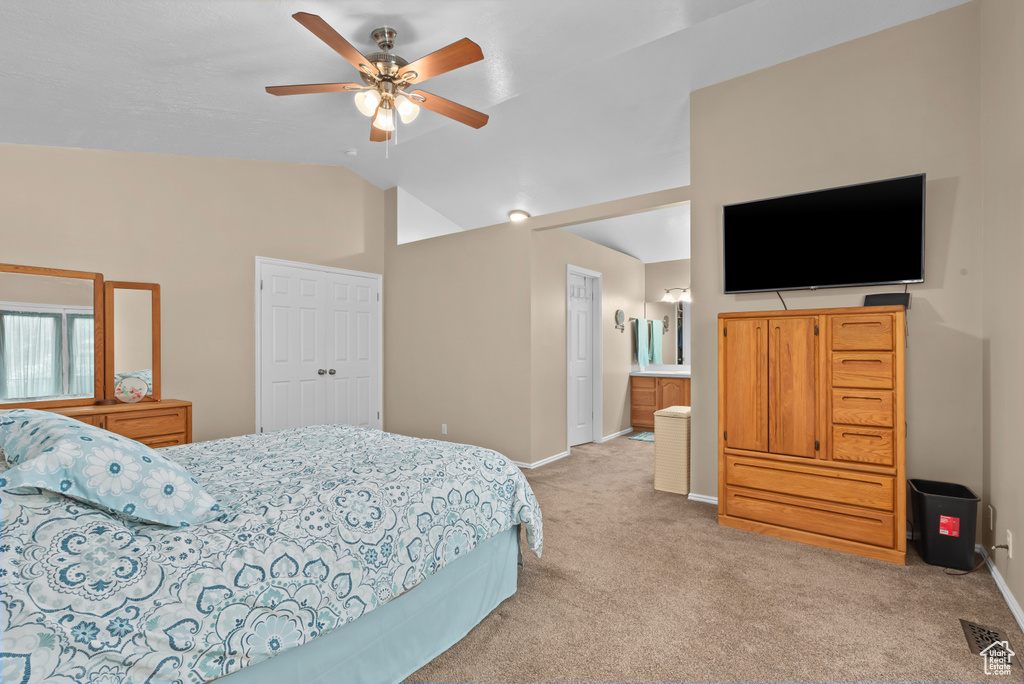 Bedroom featuring high vaulted ceiling, ensuite bath, ceiling fan, light carpet, and a closet