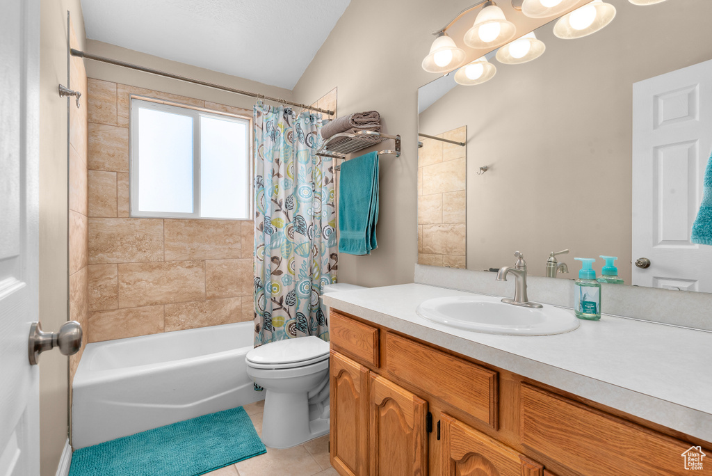 Full bathroom with shower / tub combo, lofted ceiling, tile floors, toilet, and vanity