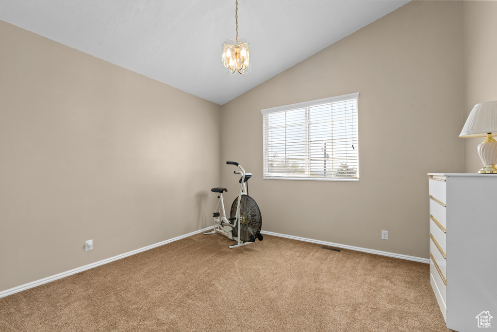 Exercise area featuring light colored carpet, a notable chandelier, and lofted ceiling