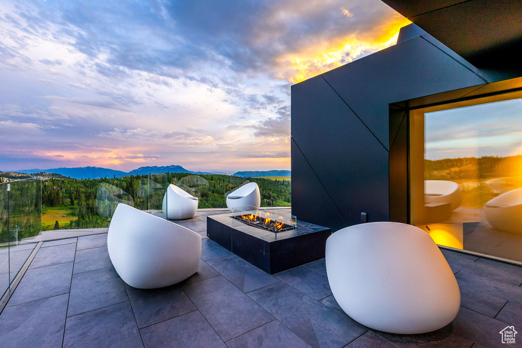 Patio terrace at dusk featuring a mountain view and an outdoor fire pit