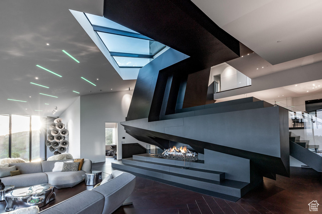Living room featuring a skylight, a towering ceiling, and a wealth of natural light