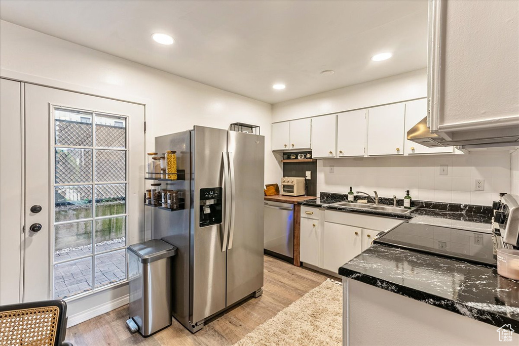 Kitchen featuring appliances with stainless steel finishes, sink, light wood-type flooring, and white cabinetry