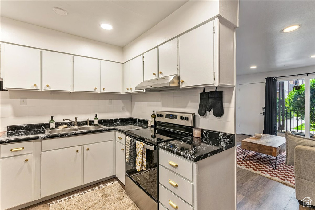 Kitchen featuring white cabinets, sink, electric range, and hardwood / wood-style floors