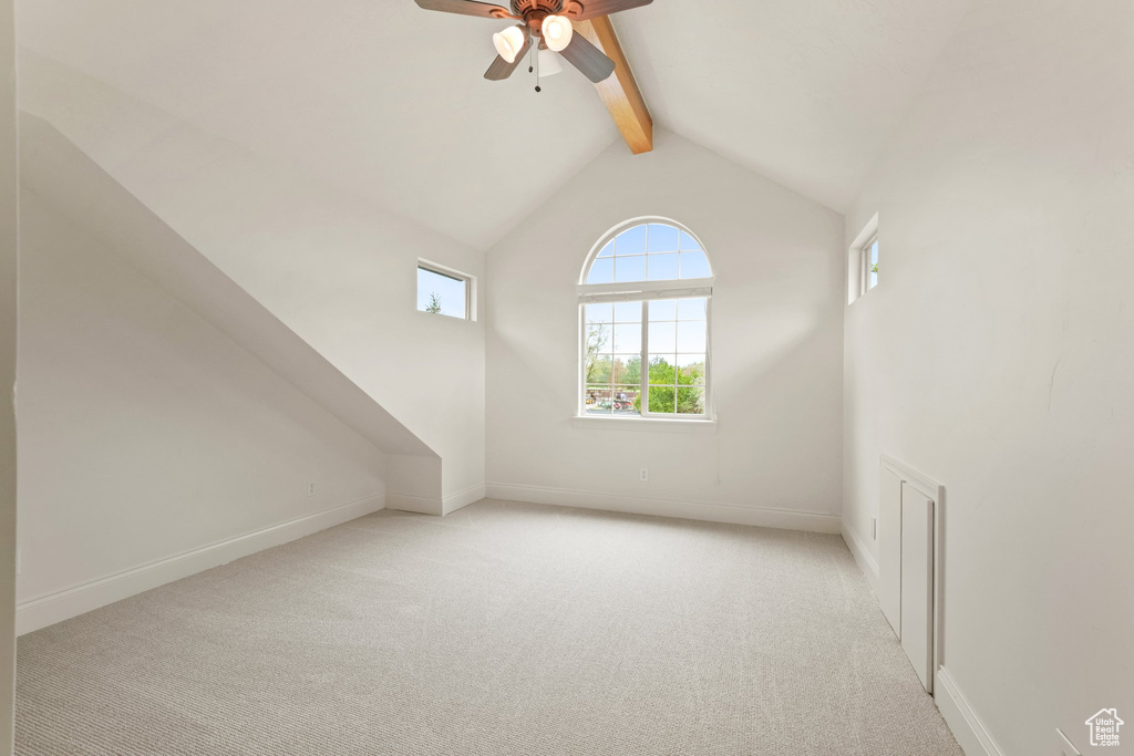 Bonus room with light colored carpet, ceiling fan, and lofted ceiling with beams