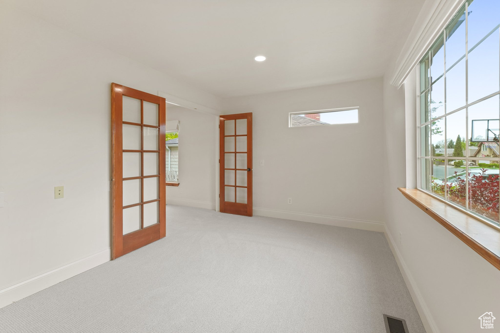 Carpeted empty room featuring french doors