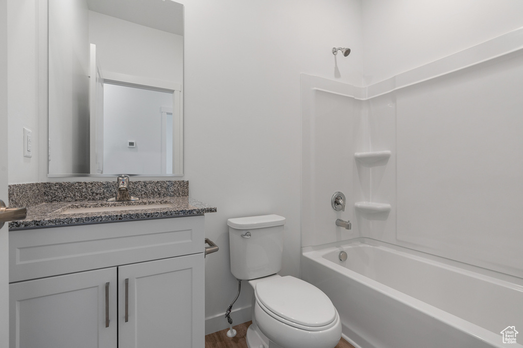 Full bathroom with wood-type flooring, toilet, vanity, and bathing tub / shower combination