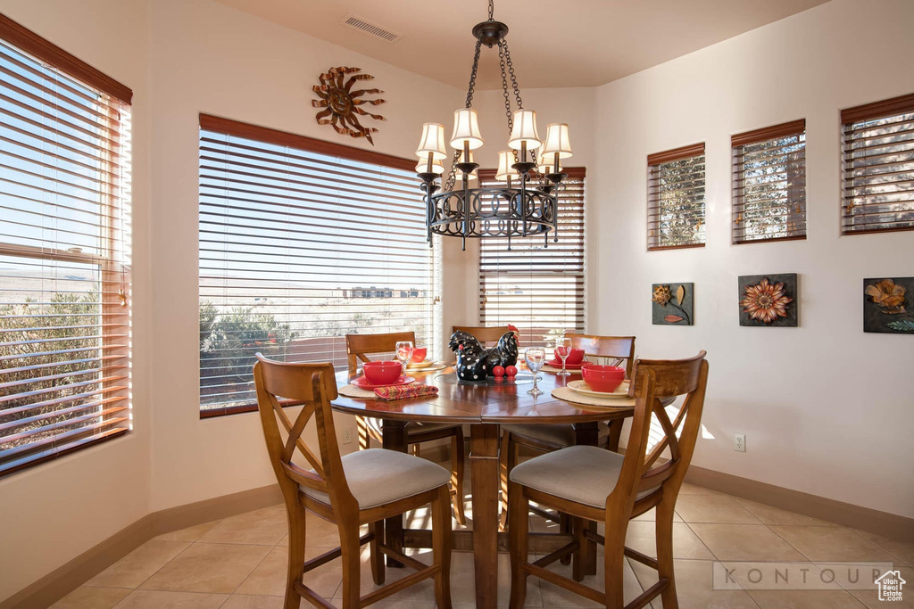 Tiled dining space featuring an inviting chandelier