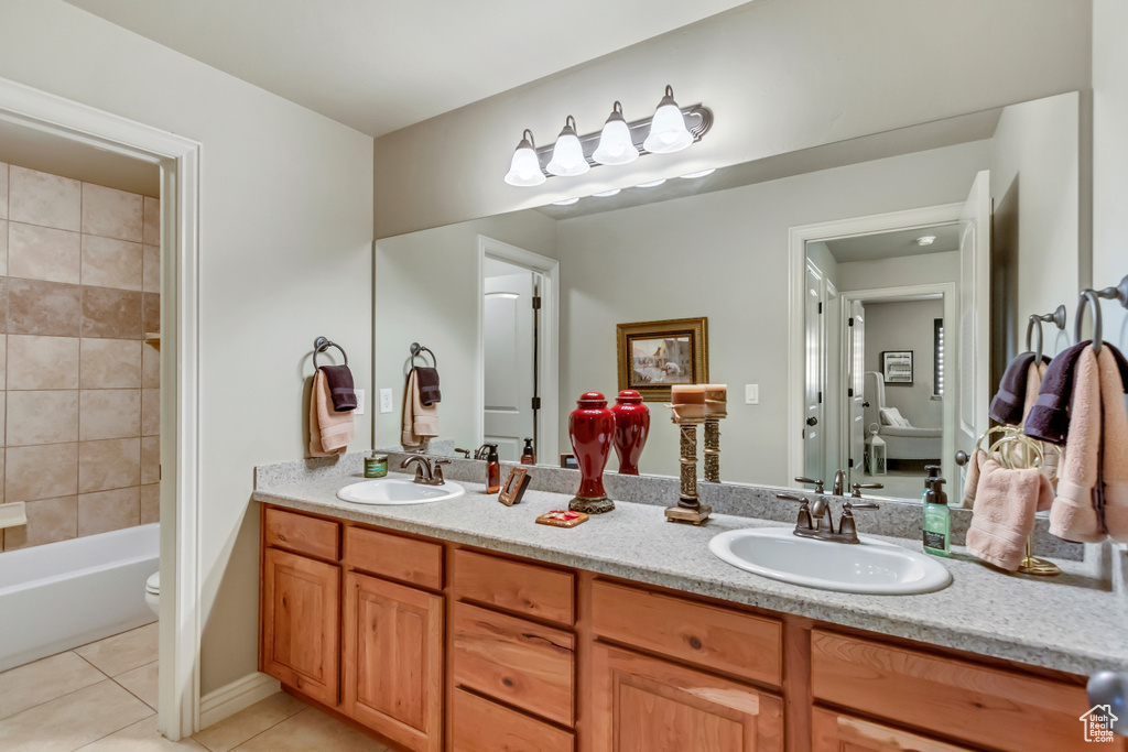 Bathroom featuring double large sink vanity, mirror, and light tile floors
