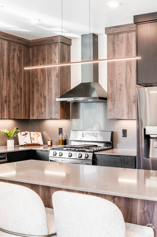Kitchen with wall chimney exhaust hood and appliances with stainless steel finishes