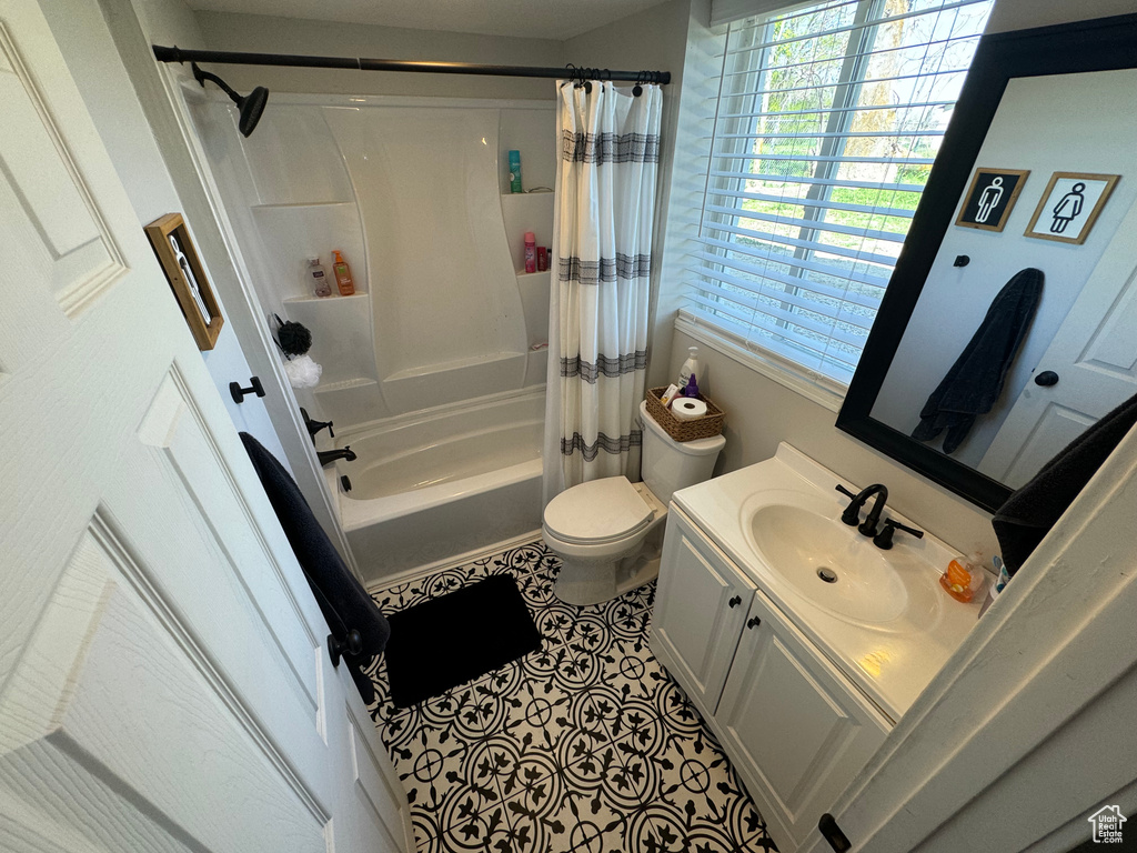 Full bathroom featuring shower / bathtub combination with curtain, toilet, tile flooring, and vanity