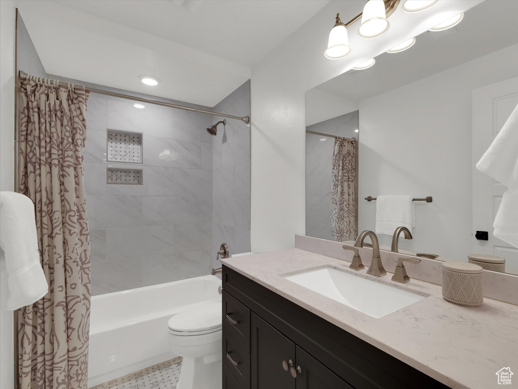 Full bathroom with tile floors, vanity, shower / bathtub combination with curtain, and toilet