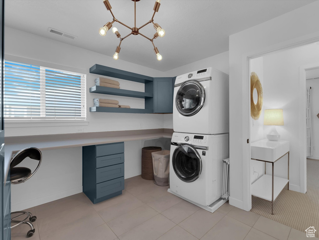 Laundry room with light tile flooring and stacked washer / dryer