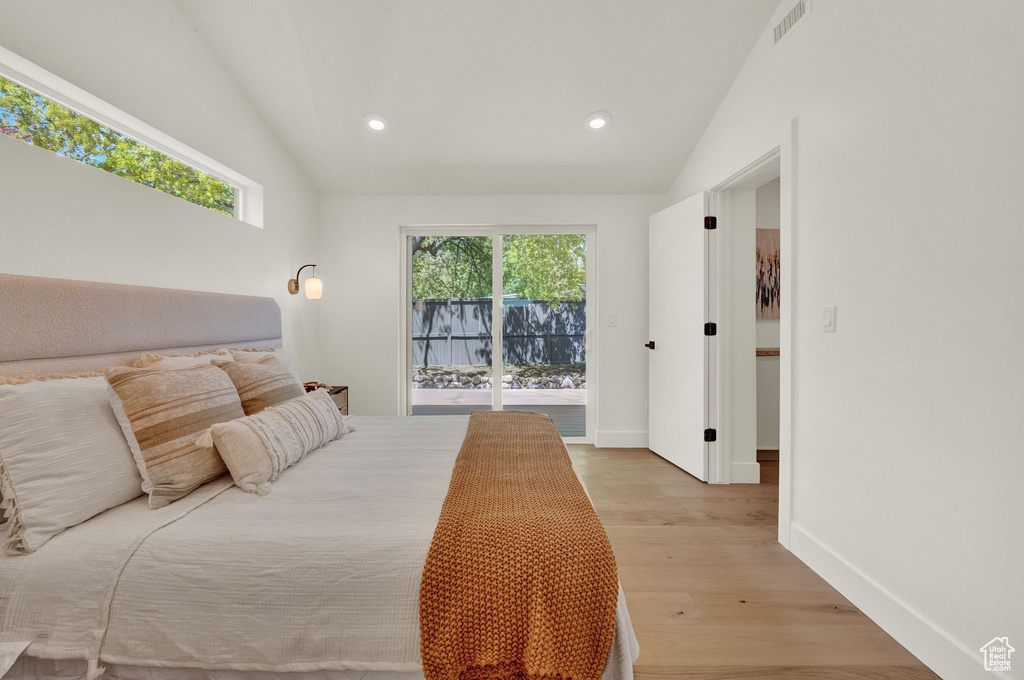 Bedroom featuring light hardwood / wood-style flooring, vaulted ceiling, and access to exterior
