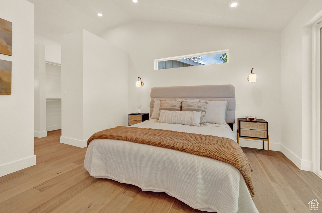 Bedroom with vaulted ceiling and light hardwood / wood-style flooring