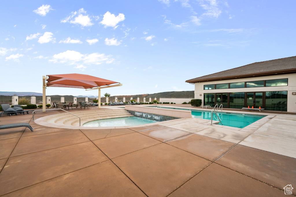 View of swimming pool with pool water feature and a patio area
