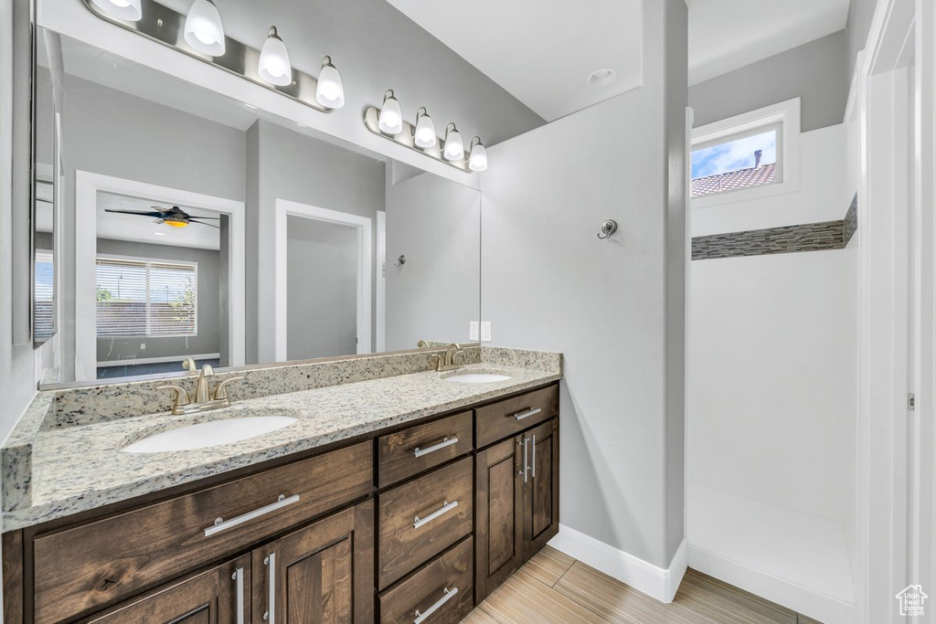 Bathroom featuring tile flooring, ceiling fan, and dual vanity