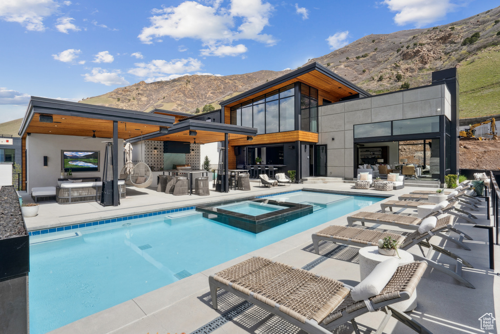 View of pool with a mountain view, an in ground hot tub, and a patio
